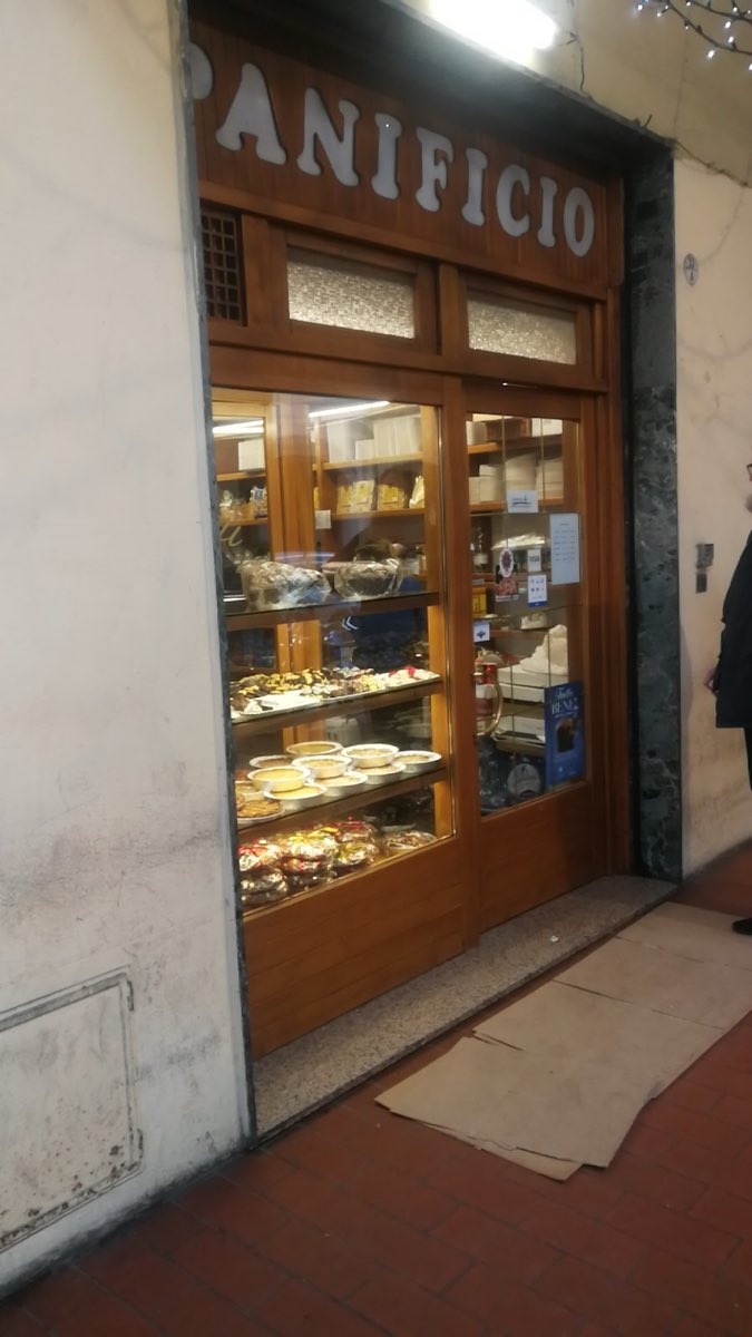 La facciata del panificio Fiorini di sera, con le grandi lettere bianche PANIFICIO sul legno